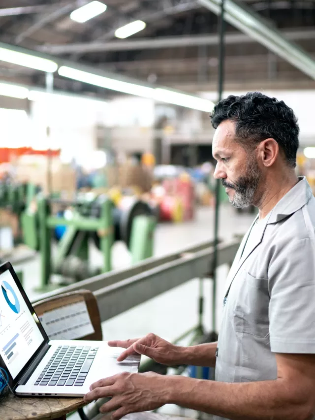 man monitoring computer in factory