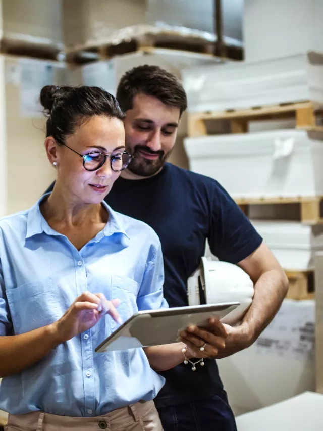 team viewing tablet in warehouse