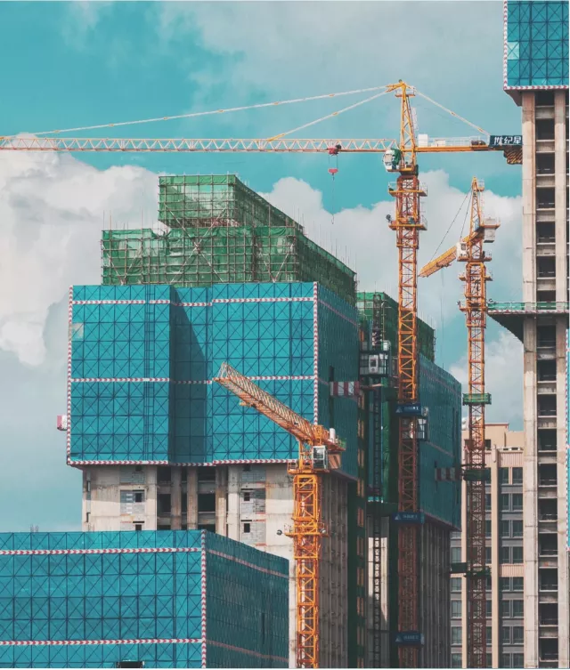 Skyscraper with construction cranes