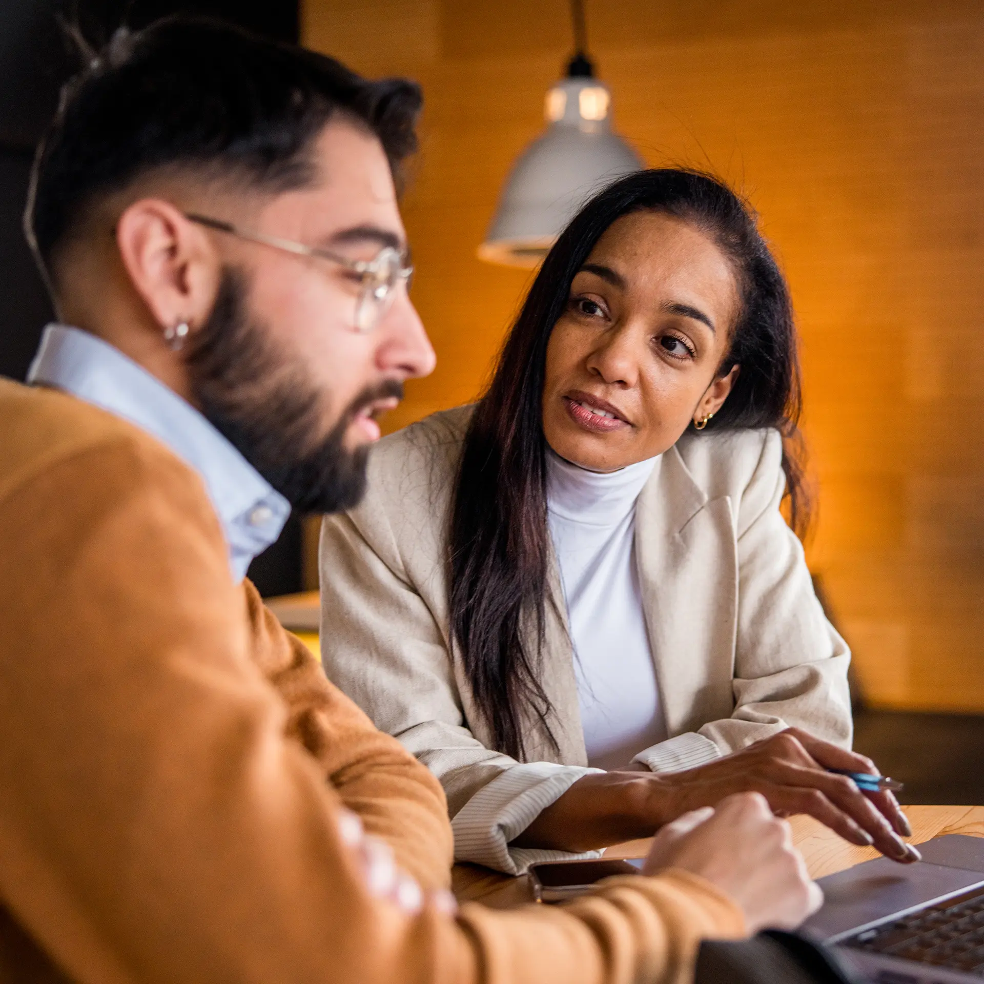 Man and woman talking while looking at a computer screen.