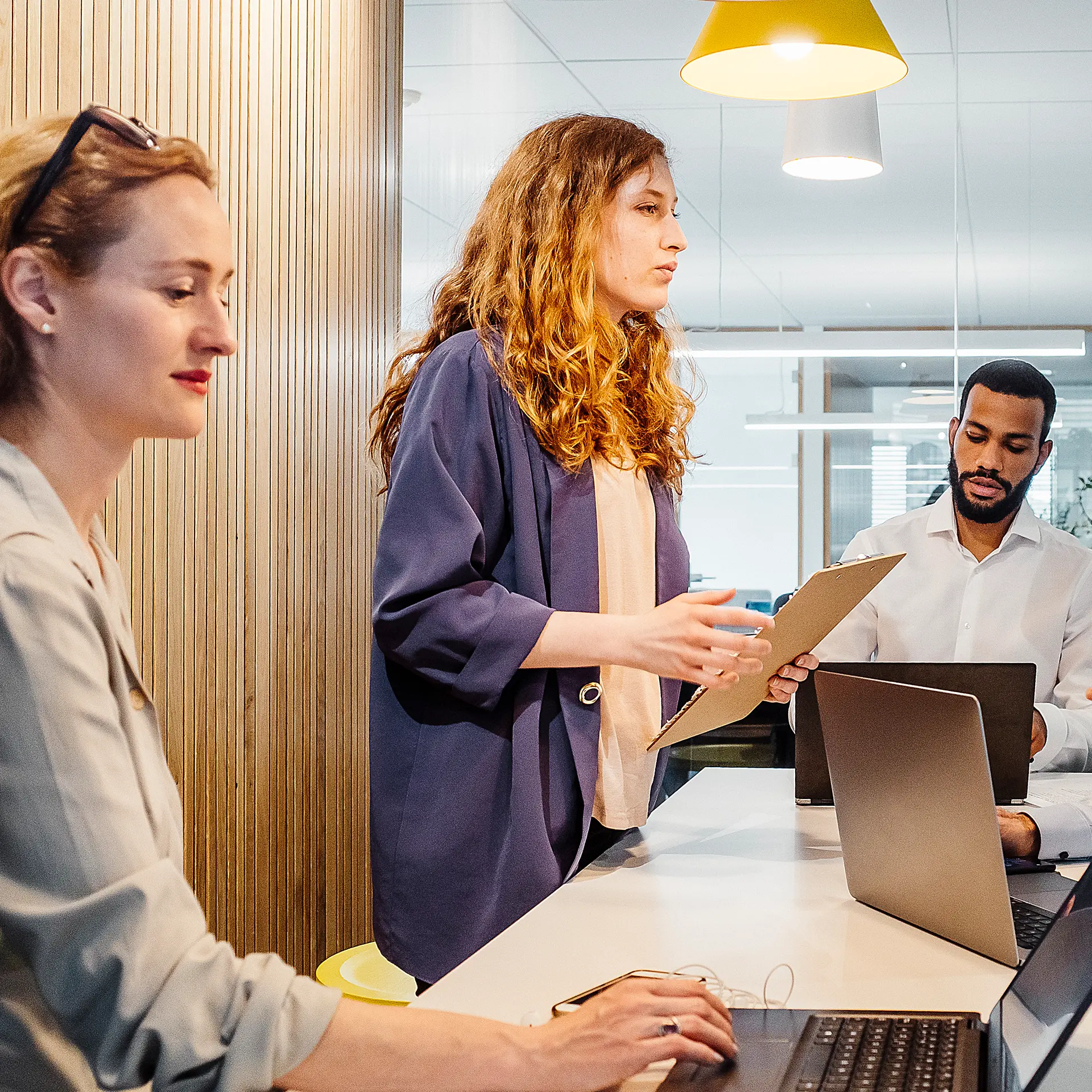 Three people in a meeting room.