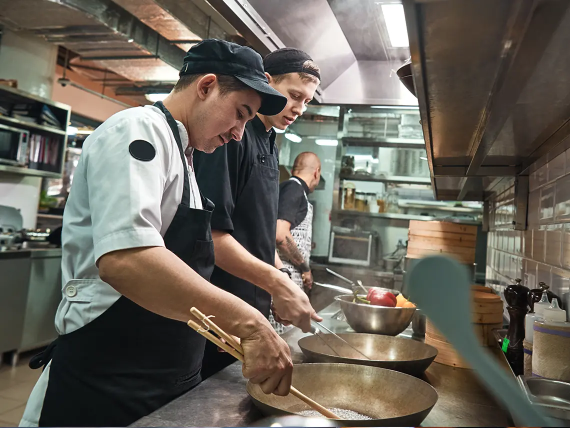 Workers in the kitchen at Cheesecake Factory.