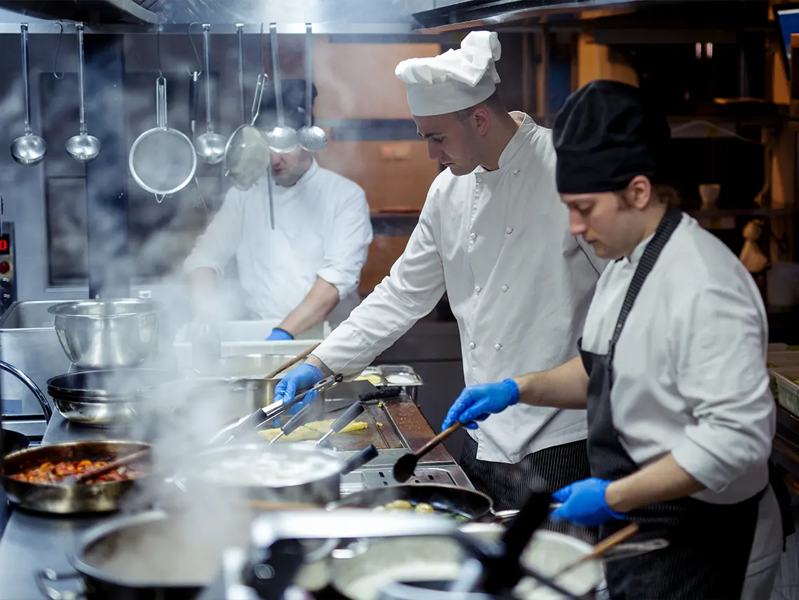 A group of chefs in a kitchen.