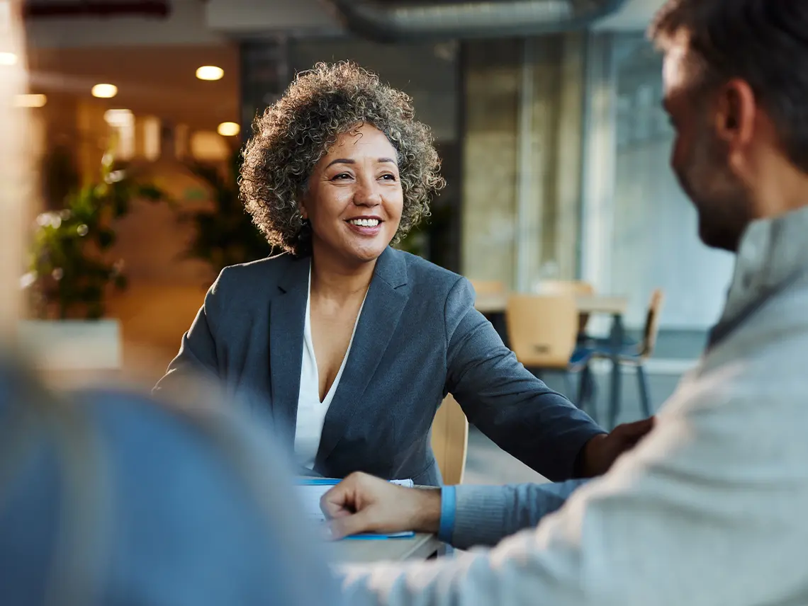 Woman in a suit talking with a man.