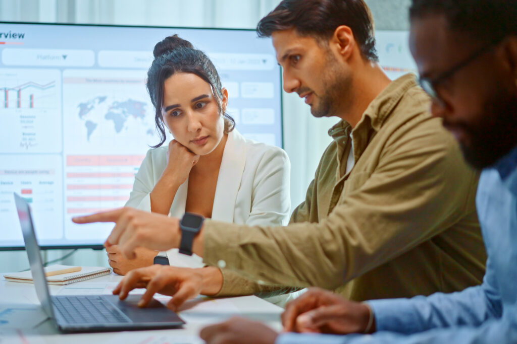 A team of multiethnic developers is meeting to discuss the data analytics of marketing.